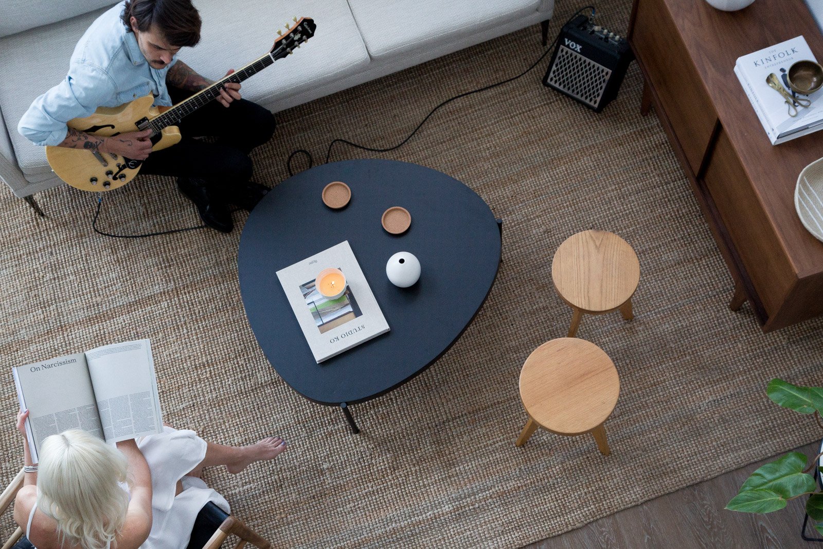 A resident at home — guitar, coffee table, books